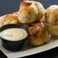 Garlic Knots With Cheese & Sauce · Warm fresh baked dough infused with garlic, parsley and topped with melted cheese, served wi...