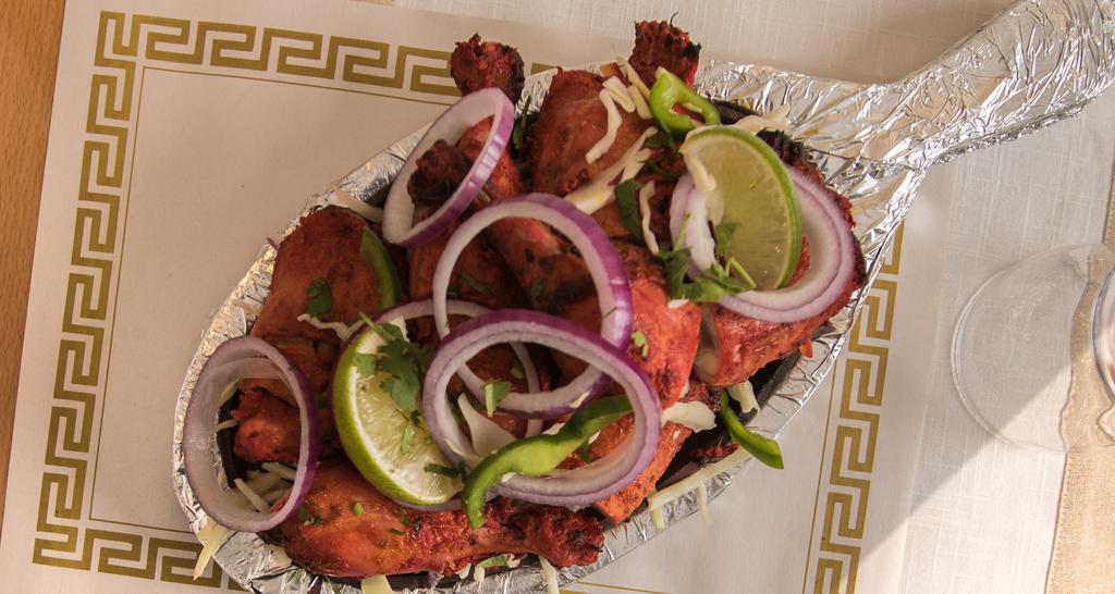 Kodi Tandoori (Chicken Tandoori - Half) · Chicken Leg And Thigh Pieces Are Marinated Overnight In Yogurt With Herbs And Spices And Cooked On Skewers In A Tandoor (Clay Oven).