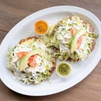 Tostadas (2) · Choice of meat . Made on a crispy corn tortilla with refried beans topped with lettuce, toma...