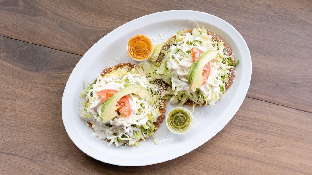 Tostadas (2) · Choice of meat . Made on a crispy corn tortilla with refried beans topped with lettuce, tomatoes, sour cream, cheese, and avocado.