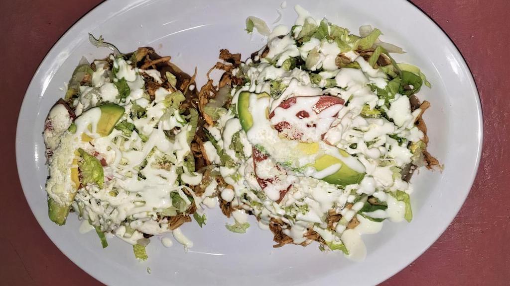 Tostadas De Tinga (2) · Pulled chicken breast cooked in chipotle tomato sauce and onion. Made on a crispy corn tortilla with refried beans topped with lettuce, tomatoes, sour cream, cheese, and avocado.