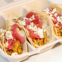 *Chicken Tinga Taco · Savory braised pulled chicken, kept in a rich tomato sauce, topped with pickled red onions, ...