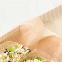 *Carne Asada Taco · Juicy skirt steak, held in a blended marinade, topped with shredded Oaxaca cheese, shaved ic...