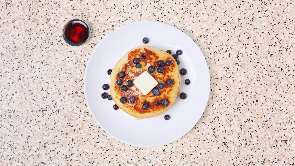 Blueberry Pancakes · Three fluffy blueberry pancakes with maple syrup and butter.