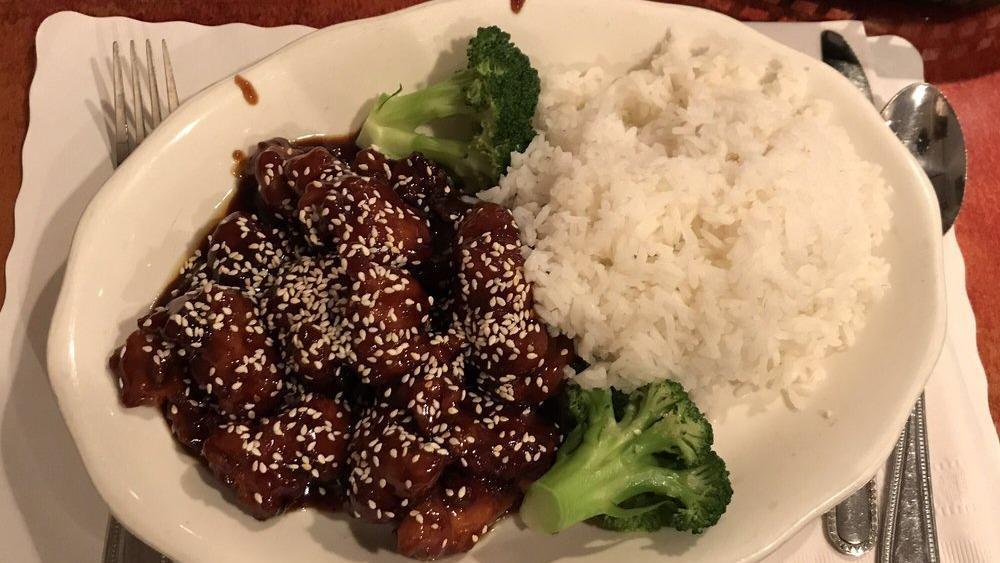 Sesame Chicken · Chunks of chicken meat with chef's special sauce, topped with sesame seeds. Steamed broccoli on the side.
