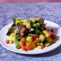 Mango Avocado Salad · Spring mix salad with mango, avocado, cucumbers, tomatoes, and yuzu ponzu.