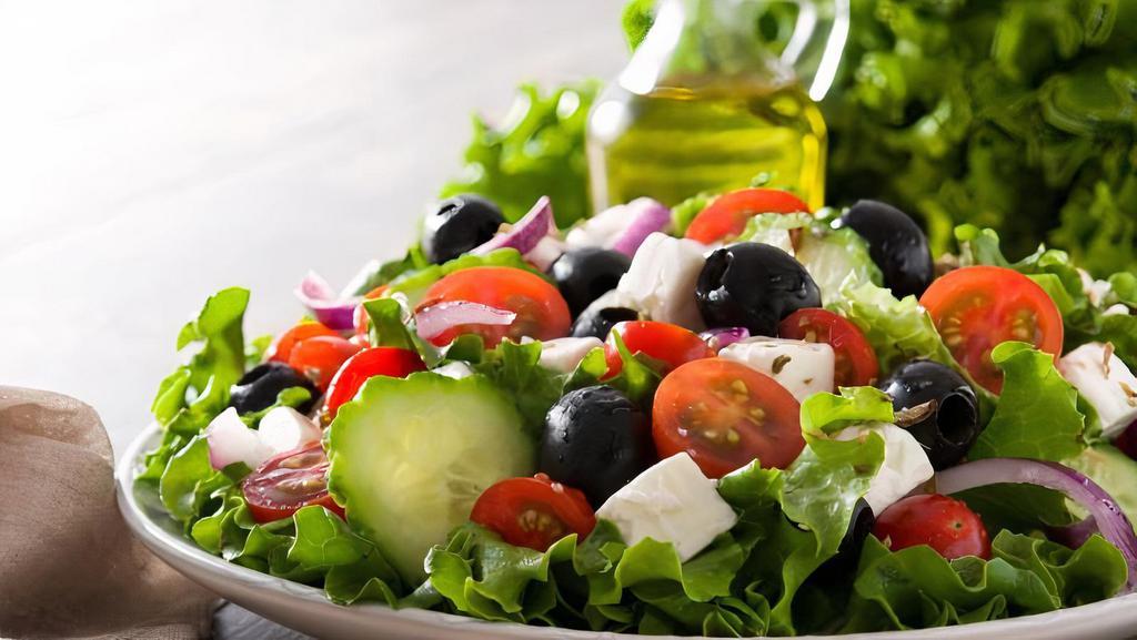 Greek Salad · Romaine lettuce, tomatoes, cucumbers, red onions, black olives, grape leaves, sweet peppers, drizzled in our special dressing. Topped with feta cheese.