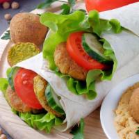 Falafel Wrap · Balls of blended chickpeas, fried, and then wrapped in a soft flour crepe with pickles, toma...