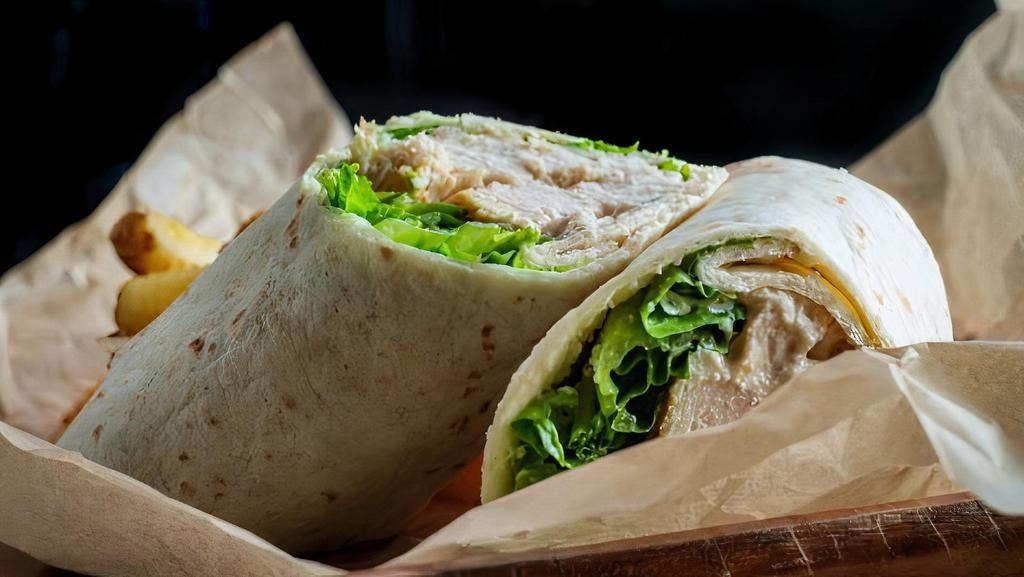 Grilled Chicken Caesar Wrap · A Caesar garlic dressing prepared over grilled chicken breast, romaine lettuce, and topped with Parmesan cheese in a soft wrap served with French fries.