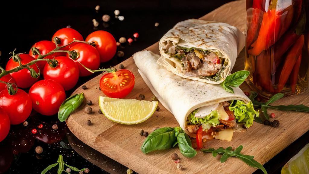 Beef Kebab Wrap · Marinated filet mignon grilled with special herbs, topped with lettuce, pickles, tomatoes, and tahini sauce in a soft flour wrap served with French fries.