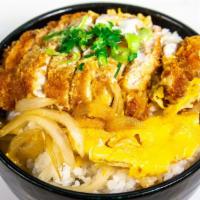 Katsu Don · Layer of pork cutlet, egg, and onions topped on a bowl of white rice.