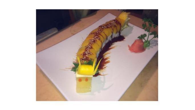 Dragon Roll · Eel & cucumber roll with avocado & tobiko outside.