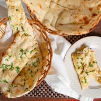 Garlic Naan · Soft bread made of white flour topped with freshly chopped garlic and coriander.