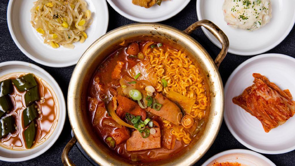 Army Stew (부대찌개) · Army Stew originated shortly after the Korean War with ingredients from American military bases. Kimchi-based stew made with sausage, spam, ramen noodles etc. * Includes rice and various side dishes.