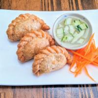 Curry Puffs · Deep-fried pastry stuffed with chicken, potatoes, onions and curry powder served with cucumb...
