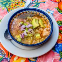 La Sopa De Pozole · Hominy corn and chicken soup in a zesty broth, accompanied by avocado, radish, oregano, and ...