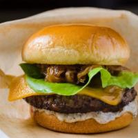 Truffle Burger · USDA Prime beef, cheddar cheese, lettuce, truffle mayo, caramelized onions, white truffle oil.