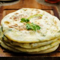 Vegan Aloo Paratha · Thick and buttery flatbread filled with tender spiced potatoes served with a side of yogurt.