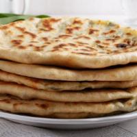 Paneer Paratha · Thick and buttery traditional bread filled with paneer cheese and served with a side of yogu...
