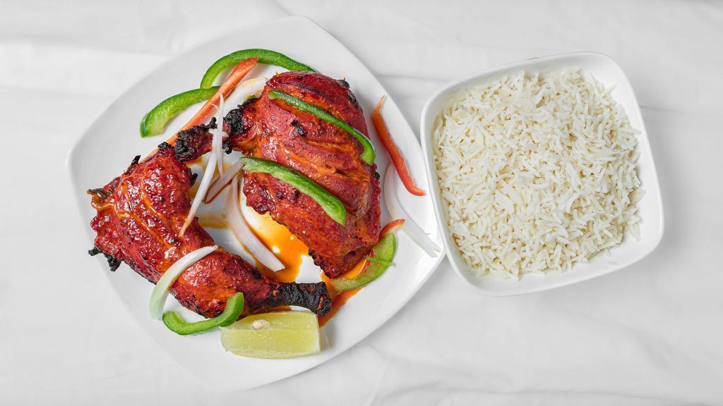 Tandoori Chicken · 1/2 chicken on the bone marinated in yogurt and spices cooked in the tandoor. Served over a bed of bell peppers and onions.