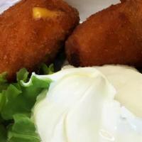 Jalapeno Poppers · Breaded jalapenos stuffed with cheddar cheese. Served on a bed of lettuce and a side of sour...