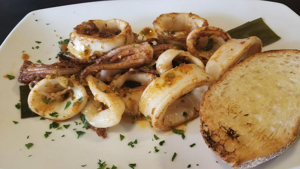 Calamares A La Parrilla · Grilled calamari in a smoked chimichurri served with grilled Cuban bread.
