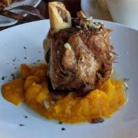 Baby Pernil (Our Specialty) · Slow roasted pork shank, with a crispy crust topped with garlic and lime mojo, served over C...