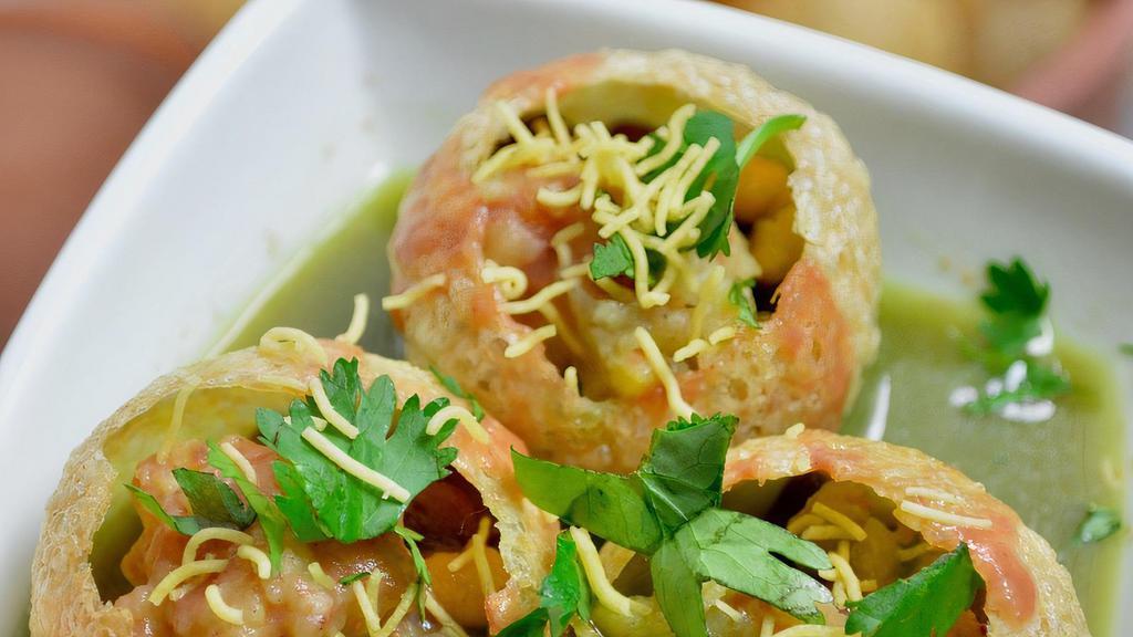 Delhi Pani Puri · Puffed puris stuffed with spicy chana and boiled potatoes, served with spicy mint water.