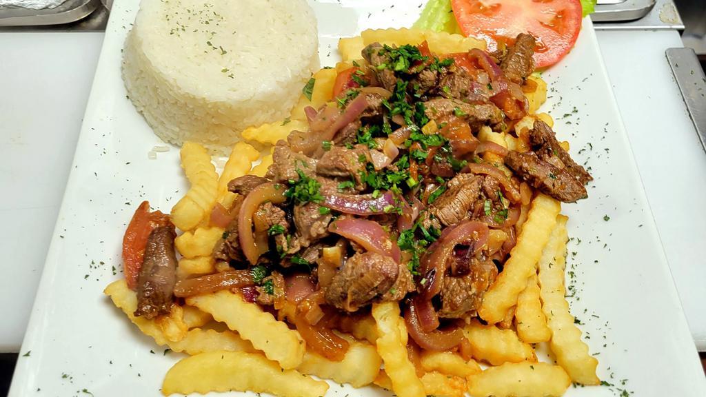 Lomo Salteado · Sautéed beef with onions and tomatoes, served over fries and rice.