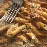 Penne Vodka · Pasta quills in a pink vodka sauce with fresh peas.