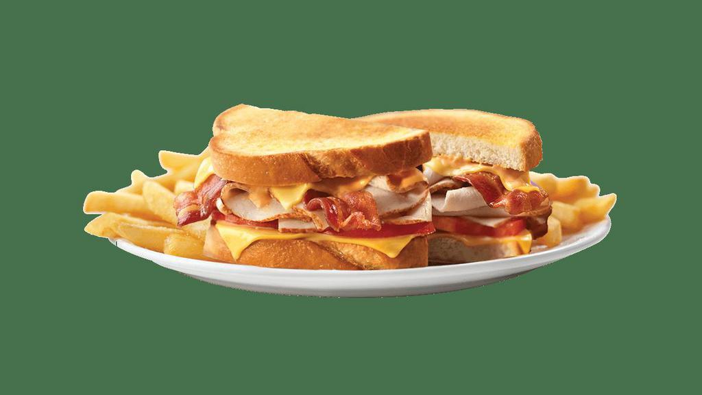 Turkey Club Supermelt® · Tasty turkey breast layered with applewood-smoked bacon, melted American cheese, tomato and Thousand Island dressing on grilled sourdough bread.   Served with a side of golden fries.
