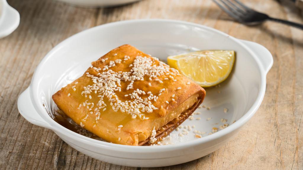Saganaki · Pan seared crispy phyllo sesame encrusted kefalograviera cheese drizzled with honey and lemon.