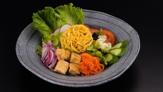 House Salad · A variety of fresh garden greens with tomatoes, cucumbers, onions & fried tofu served with your choice: ginger or peanut dressing.