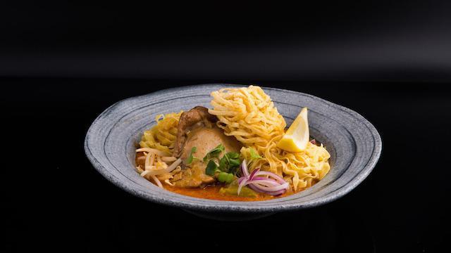 Khao Soi · Spicy. The best way to get to chiang mai without getting charged extra for luggage. Northern Thai egg noodles in our super special curry broth, pickled mustard, red onions & dried shallots, topped with crispy noodles. We only make this dish with chicken on the bone and shrimp, because we think it’s the best way to do it.