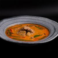 Panang Curry · Spicy. String beans, bell peppers & kaffir lime leaves simmered in coconut milk with panang ...