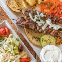 Lamb Shish Kebab Platter · 2 skewers Chargrilled. Served with Greek salad, pita bread, tzatziki sauce, garnished with t...