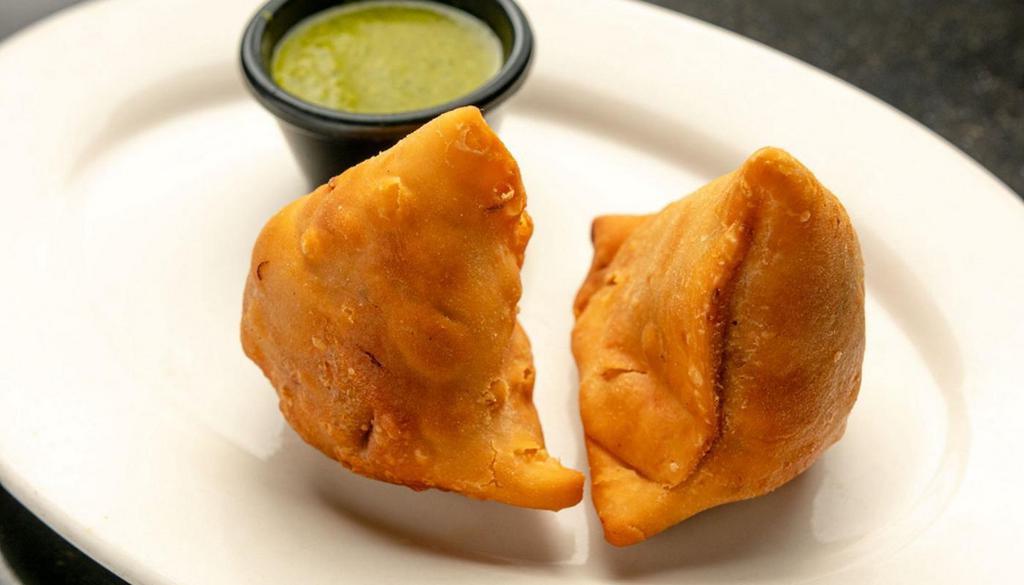 Chicken Samosa · Two Crispy samosas deliciously filled with mildly spiced minced chicken. (keema) and green peas.