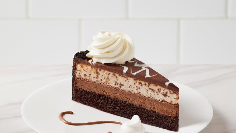 Chocolate Tuxedo Cheesecake · Layers of moist chocolate fudge cake, rich chocolate cheesecake, and vanilla mousse baked on a chocolate crumb, and topped with dark chocolate ganache.