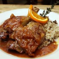 Duck Legs Confit · Slow-braised duck legs, grand marnier, and orange reduction, served with blueberry barley ri...
