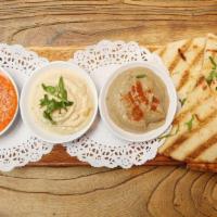 Mediterranean Dipping Tray · Hummus, Babaganush and roasted peppers with feta and grilled pita bread.
