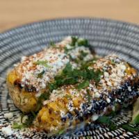 Mexican Street Corn · Grilled sweet corn on the cob with aioli, cotija cheese, cilantro, chili and lime.