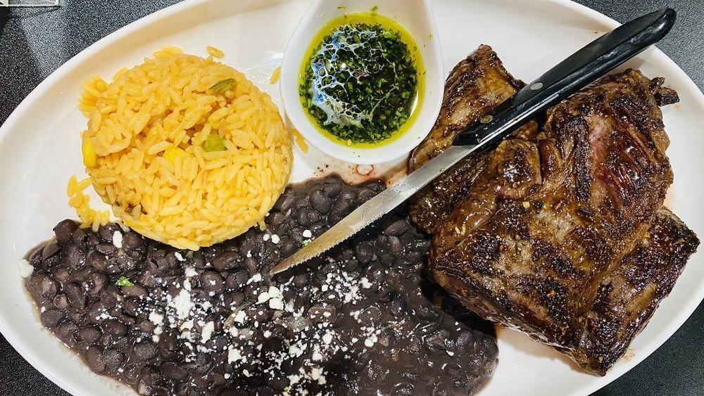 Chimichurri Steak · Grilled skirt steak, with chimichurri sauce served with rice and beans.