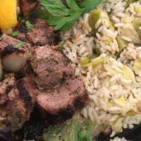 Arni Souvlaki · Lamb kebab with grilled onions and peppers over a leek and rice pilaf.