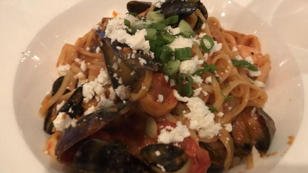 Thalassini Makaronada · Linguini with shrimp, mussels and calamari in tomato sauce topped with feta cheese.