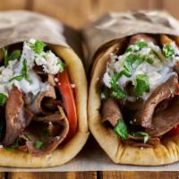 Lamb Gyro On Pita · Delicious juicy lamb gyro on a pita, served with lettuce, tomatoes, green peppers, onions, o...