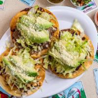 Chorizo Tostadas · Crunchy tortilla with refried beans, lettuce, avocado, Cotija cheese and sour cream.