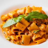 Broccoli Rabe & Sausage Rigatoni · Homemade short rigatoni tossed with broccoli robe, sausage, and sweet peppers in a pink vodk...