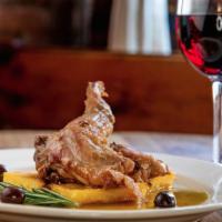 Coniglio In Intingolo  · Braised rabbit with olives, capers, prosciutto, and rosemary with polenta crostini.