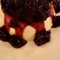 Flourless Valrhona Chocolate Cake · With raspberry coulis and whipped cream.