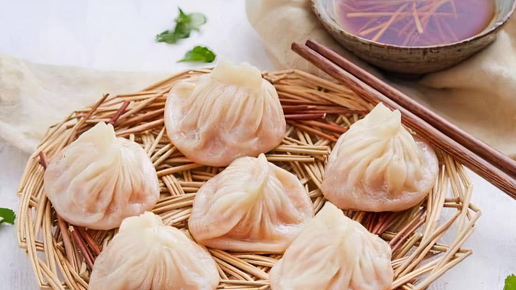 Steamed Little Juicy Dumplings (6 Pieces) / 上海小笼汤包 · Hand made soup little dumplings filled with minced pork, wrapped in a wheat flour wrapper, served with fresh ginger, vinegar dipping sauce.